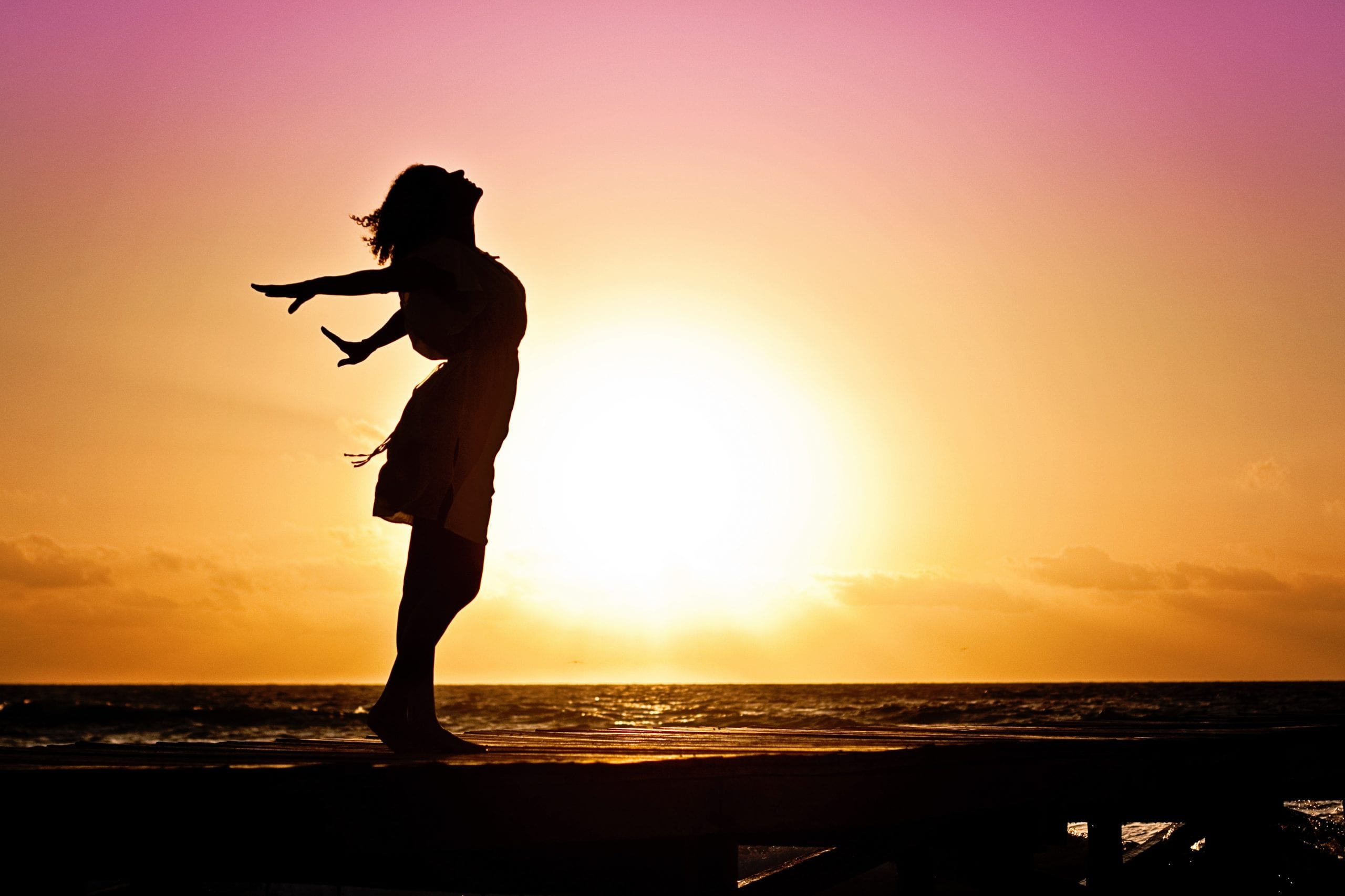 Silhouette of Woman with arms stretched - free and happy